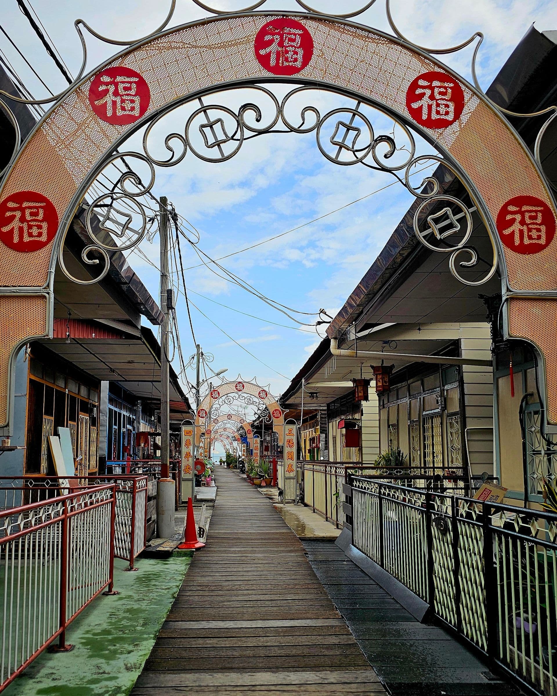 The wooden walkway of Chew Jetty extending over the harbour